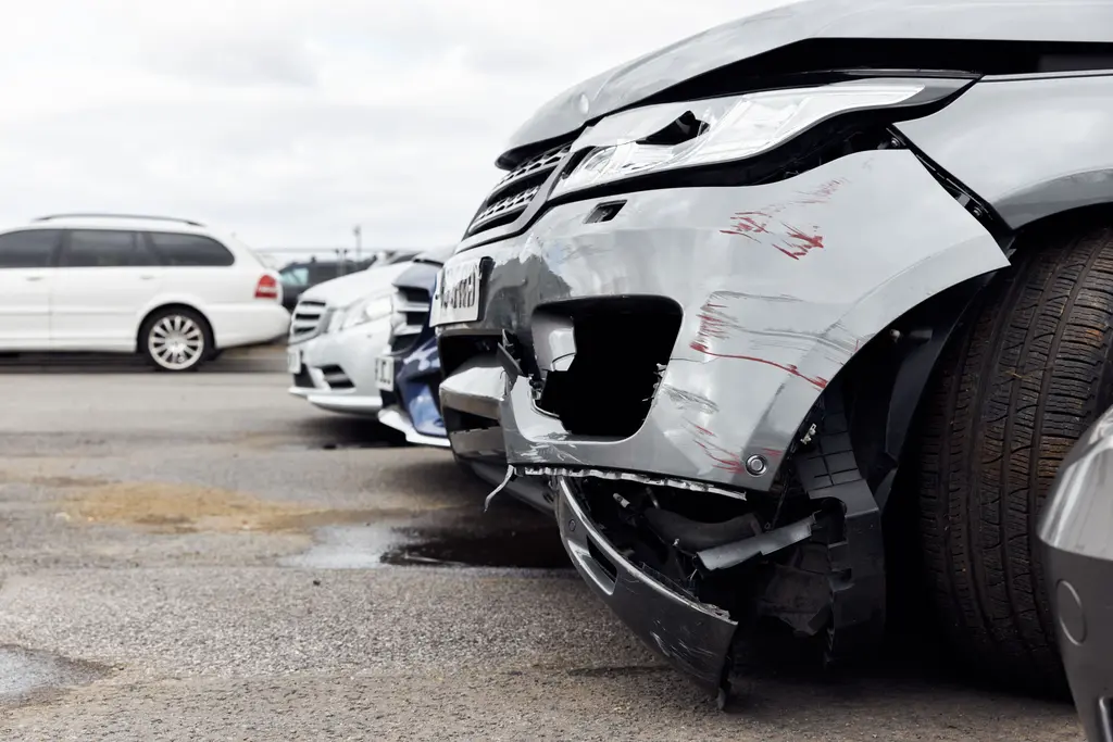 Car with front-end damage parked on a city street after a crash