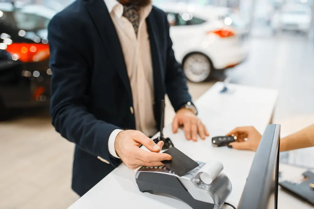 Driver picking up keys to a rental car while their own car is repaired