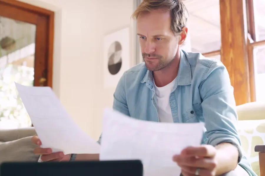 Homeowner reading a letter from an insurer next to a property insurance policy