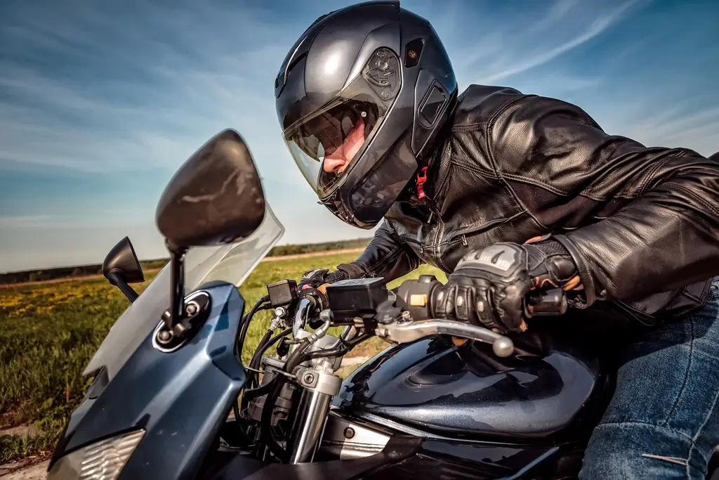 Motorcycle rider wearing a helmet and a bright reflective jacket